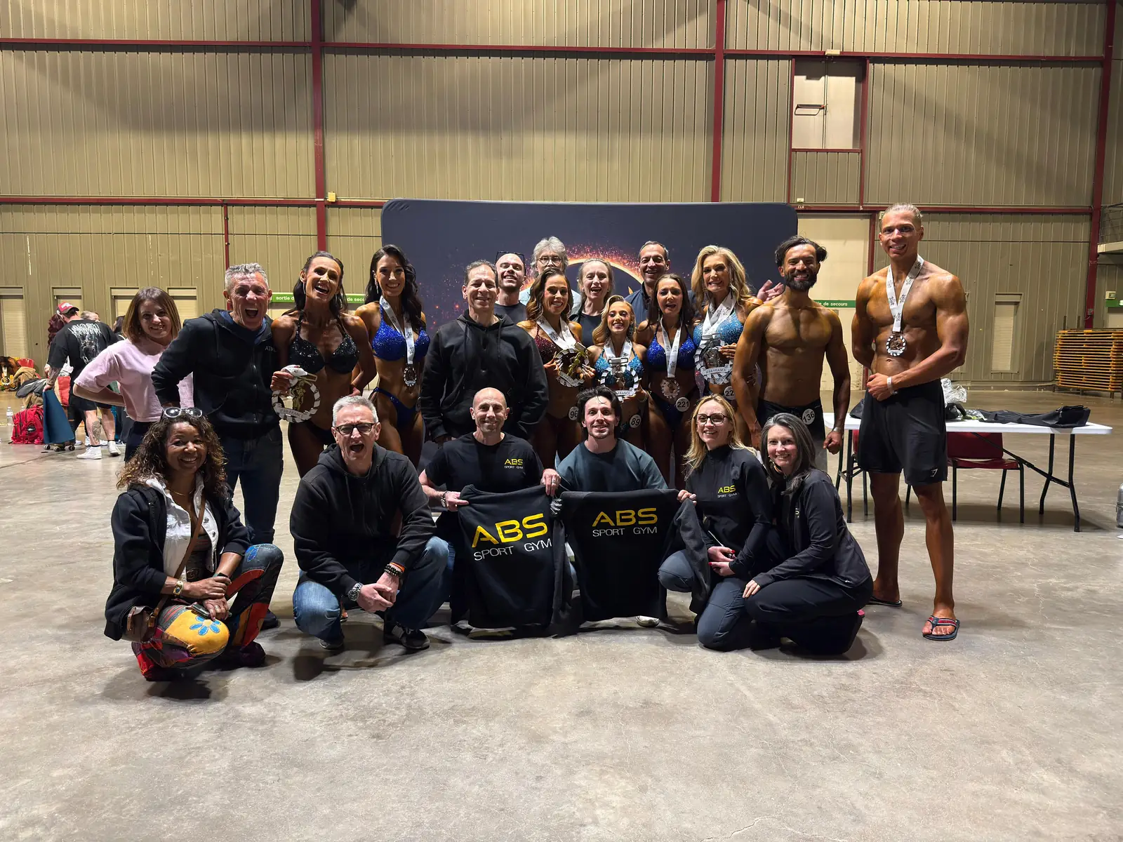 L’équipe d’ABS Sport Gym et ses athlètes réunis en compétition, autour du drapeau du club