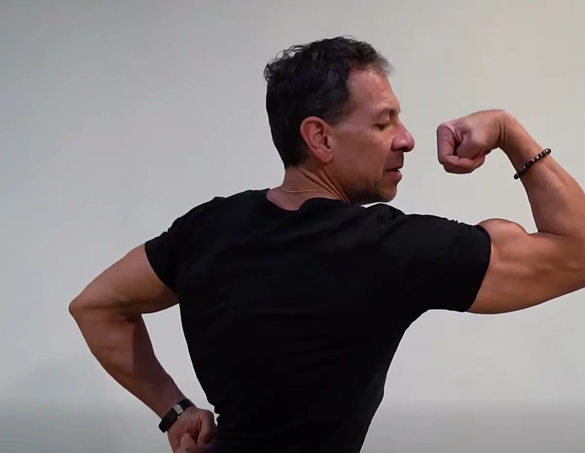 Louis Milane, coach d’ABS Sport Gym, montre une pose de biceps pendant une séance de posing