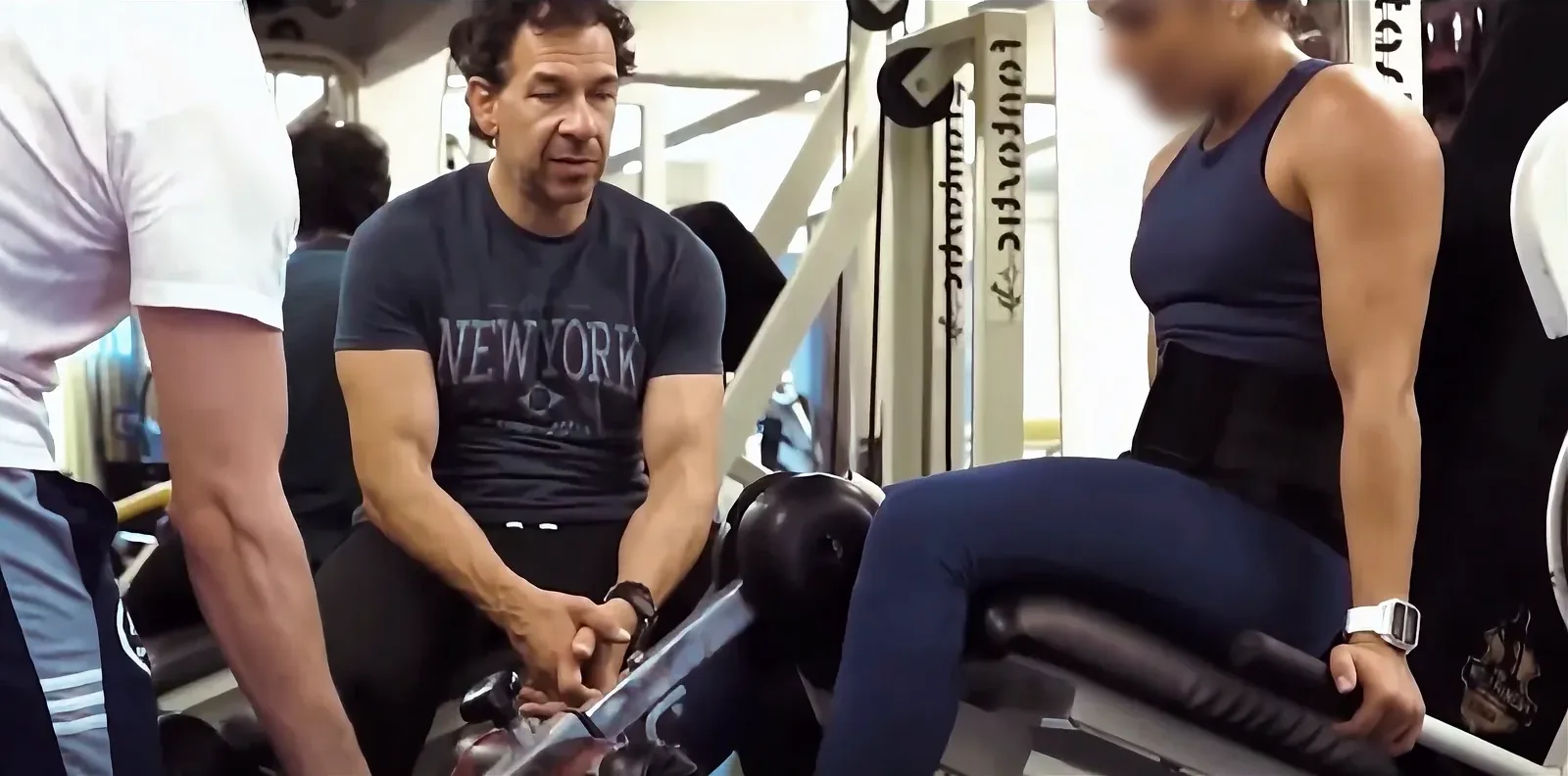 Un coach d’ABS Sport Gym accompagne une adhérente sur une machine de musculation